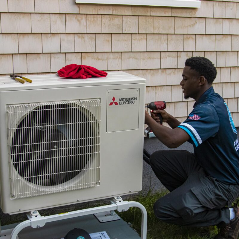 technician working on condenser outside home