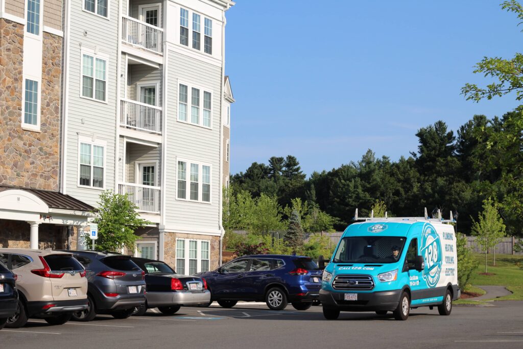 128 plumbing truck driving past apartment building