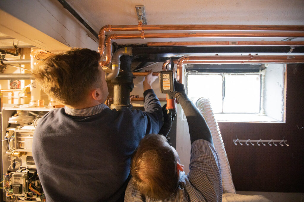 128 Plumbing technicians servicing pipes of a heating system