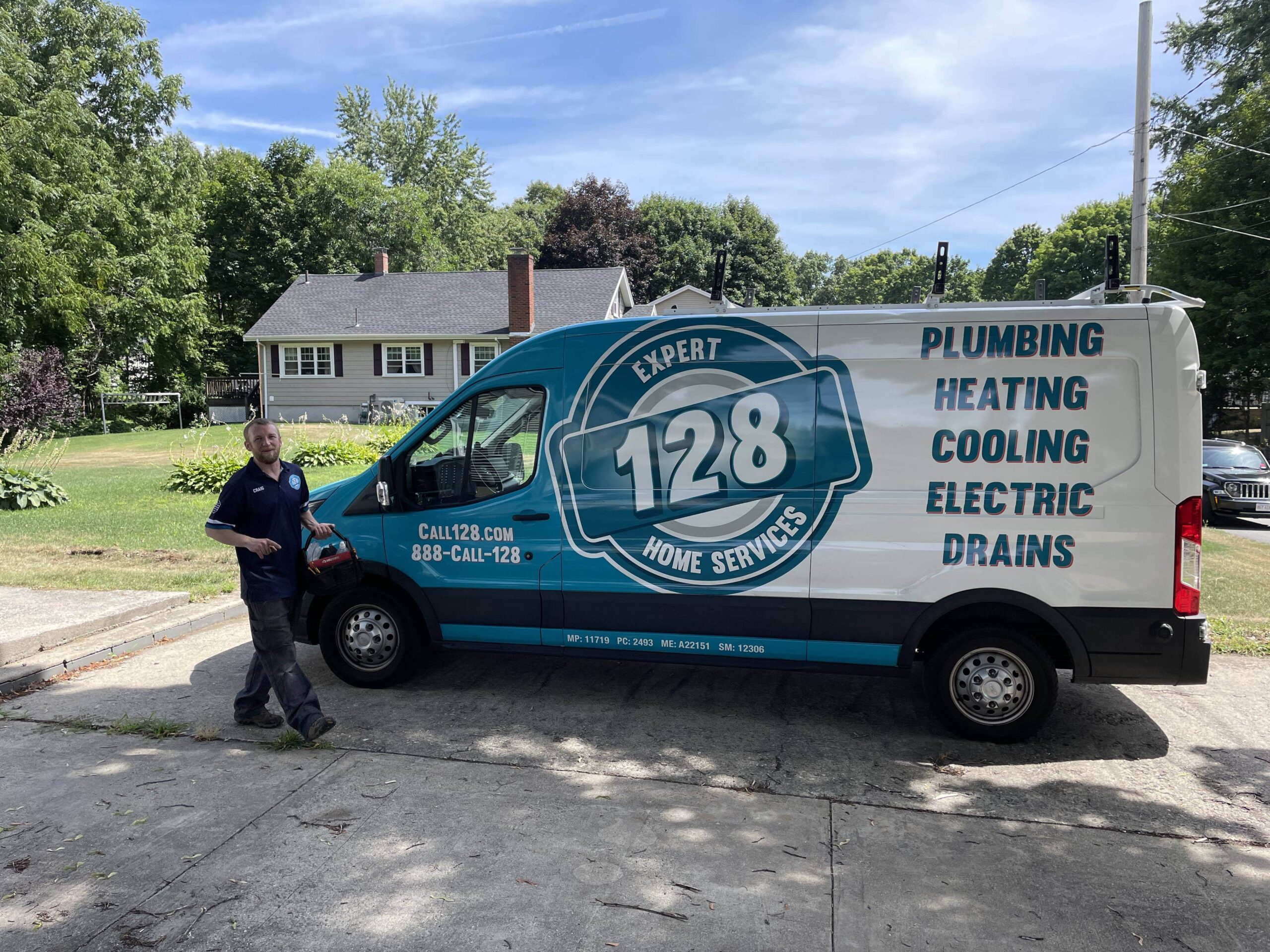 A man stands beside a van labeled "128 Home Services" with services including plumbing, heating, cooling, electric, drains. A house and trees are in the background.