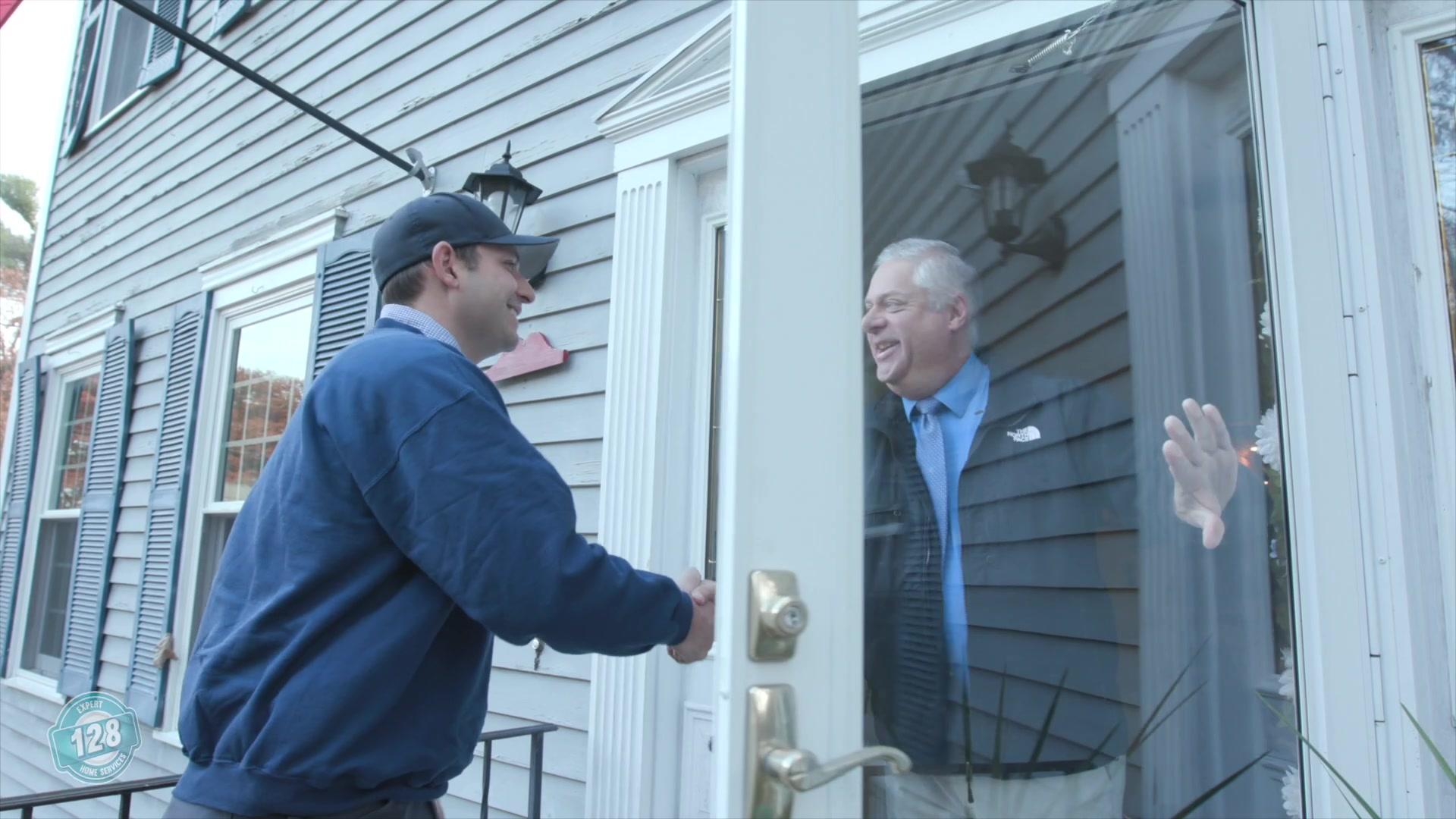 A trusted electrician shaking the hand of a satisfied customer in Milton MA from 128 Plumbing expert electrician services.