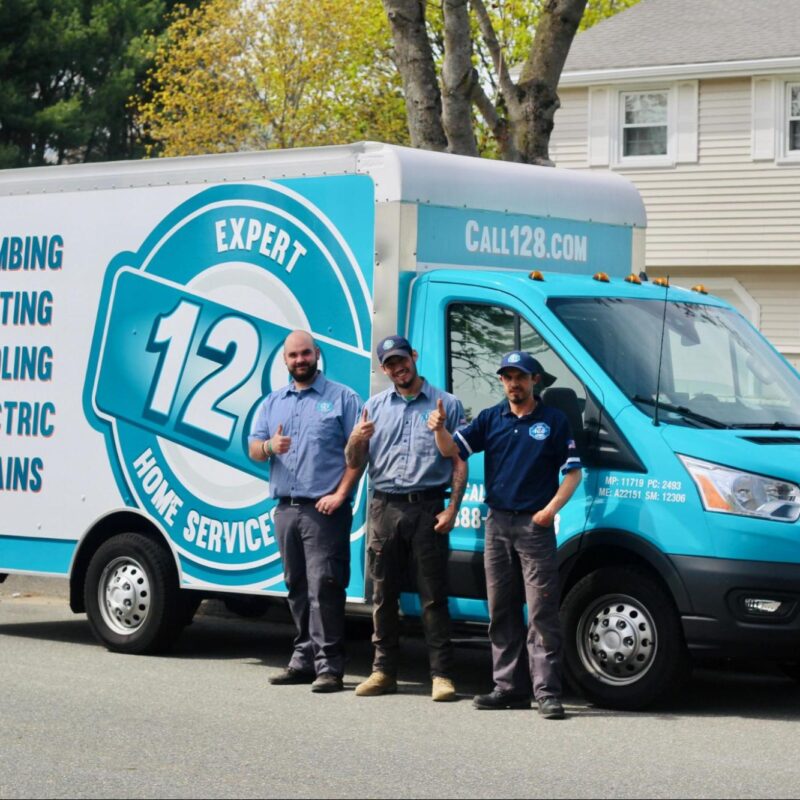 Three workers for 128 Plumbing an air conditioning company in Lexington MA smiling in front of truck.