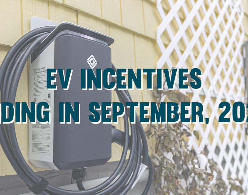 Close-up of an electric vehicle charging station mounted on a yellow house wall, with text stating EV incentives end in September 2025.
